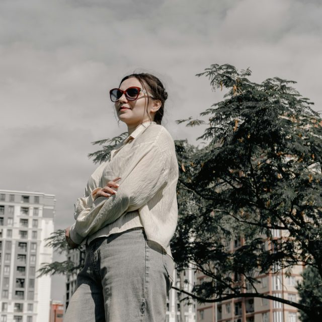 Street style: женщина в кремовой рубашке и джинсах на фоне города