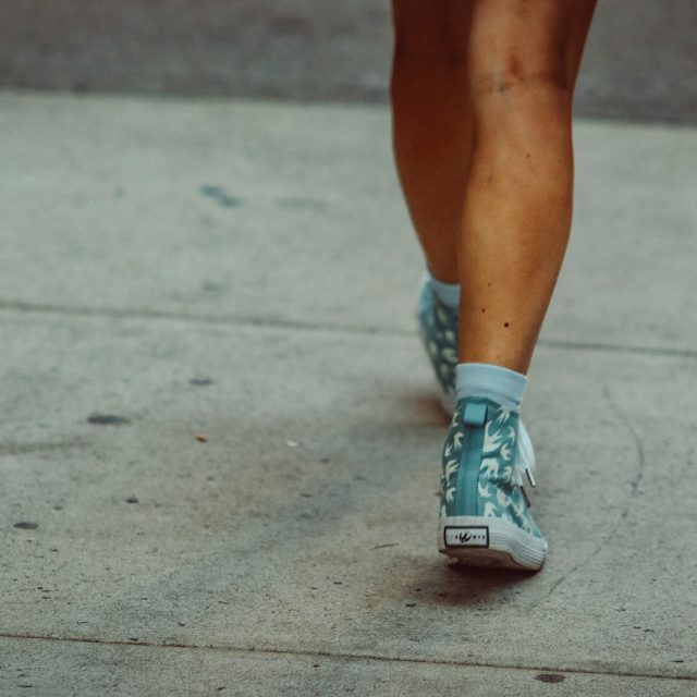 Legs and feet walking on a sidewalk