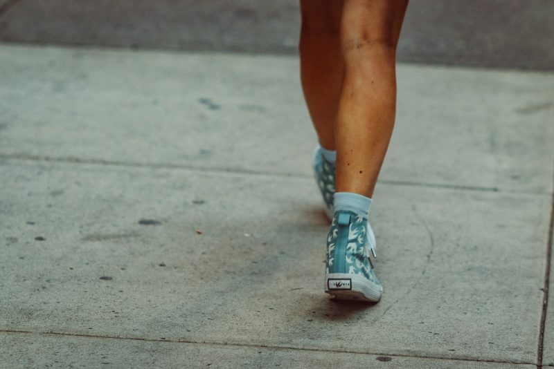 Legs and feet walking on a sidewalk