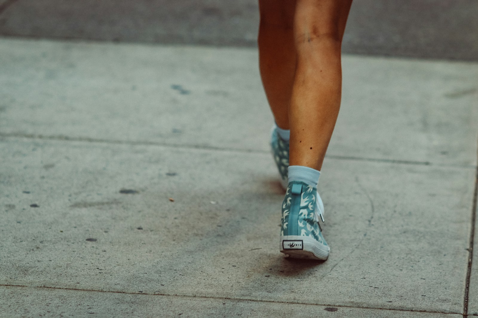 Legs and feet walking on a sidewalk