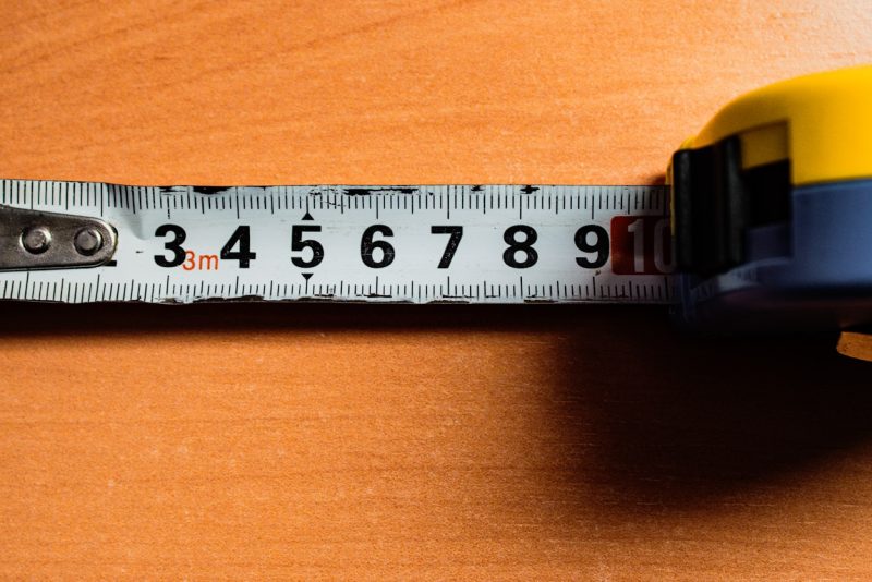 A tape measure is on a wooden table